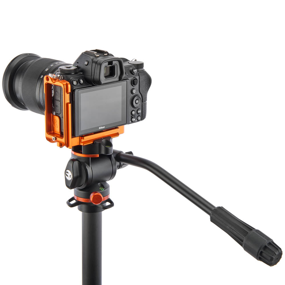 Camera mounted on an orange and black tripod with a white background