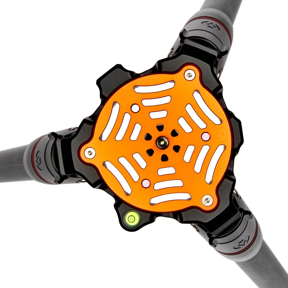 An orange and black 3-way handlebar connector with white vented slots, mounted on three gray bicycle handlebars against a white background.