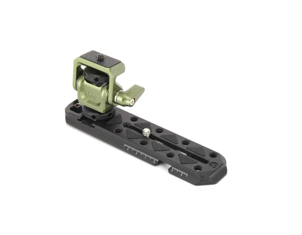 Camera accessory with green clamp and black base on a white background