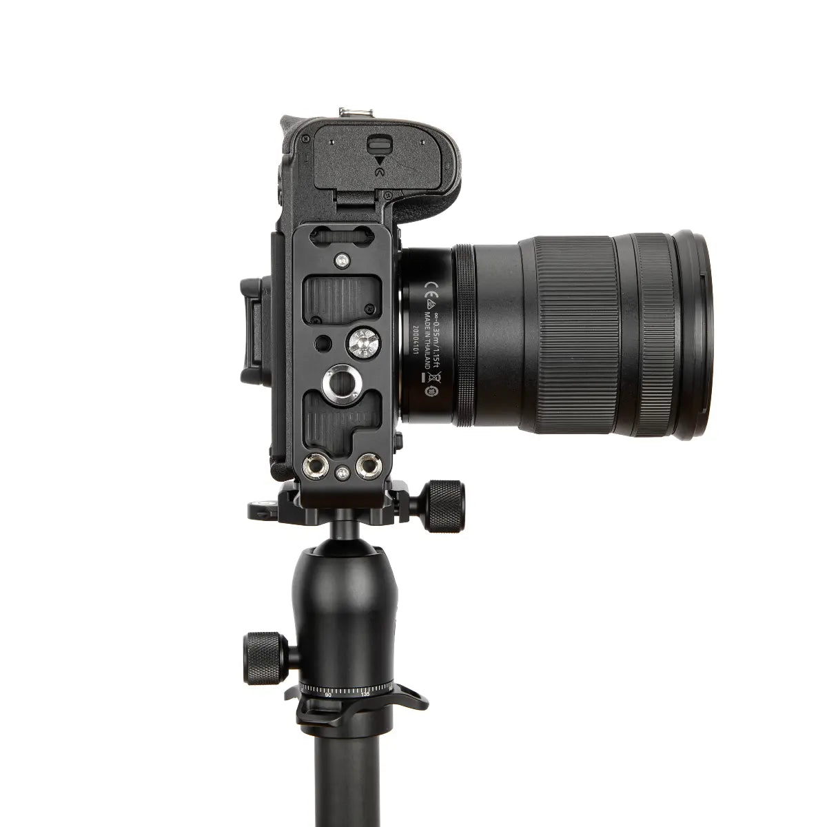 Camera with lens on a tripod against a white background