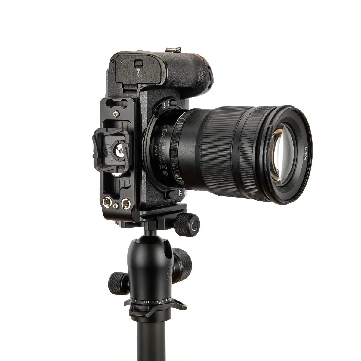 Camera with lens on a tripod against a white background