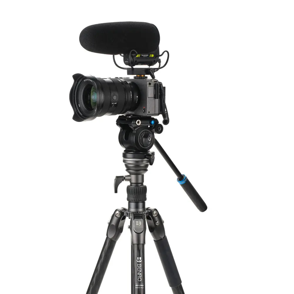 Camera with microphone on a tripod against a white background