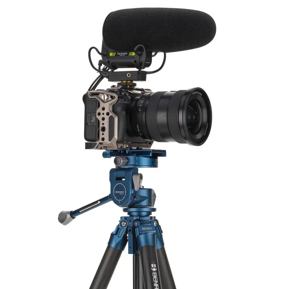 Camera with microphone on a tripod against a white background