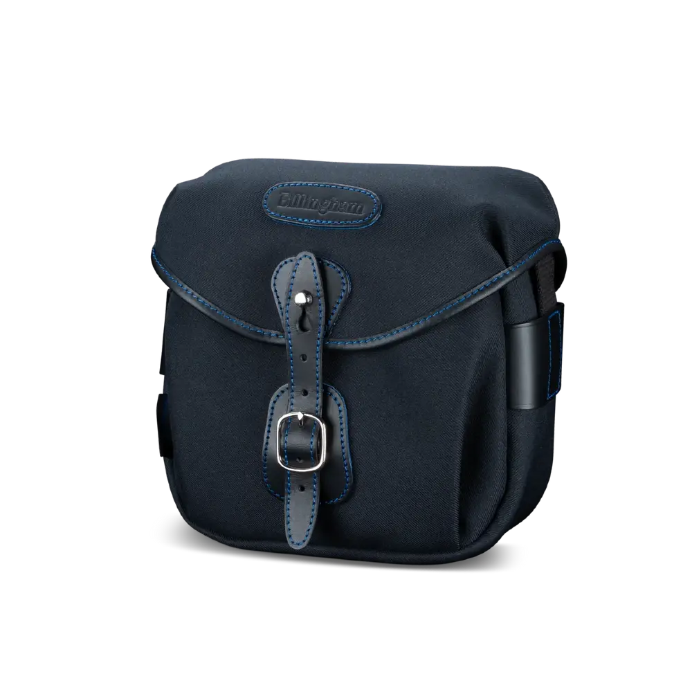 Navy blue bag with leather strap and buckle on a white background