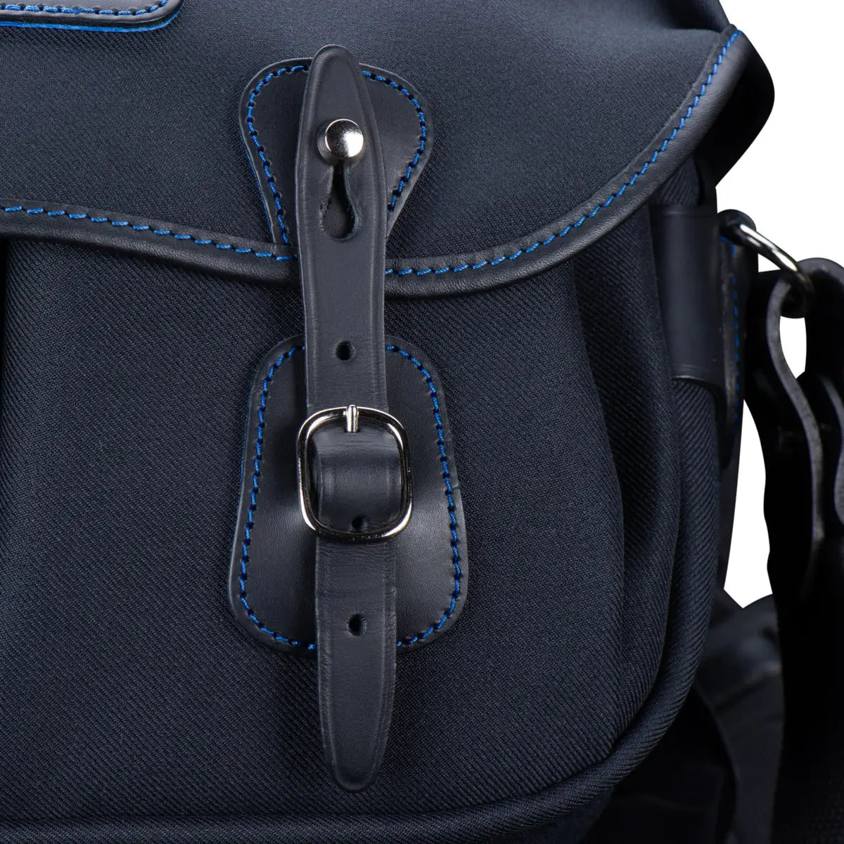 Close-up of a navy blue backpack with leather strap and buckle on a white background