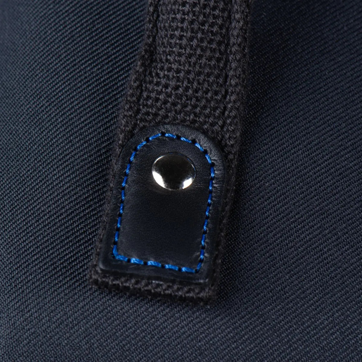 Close-up of a black button on a textured dark fabric background