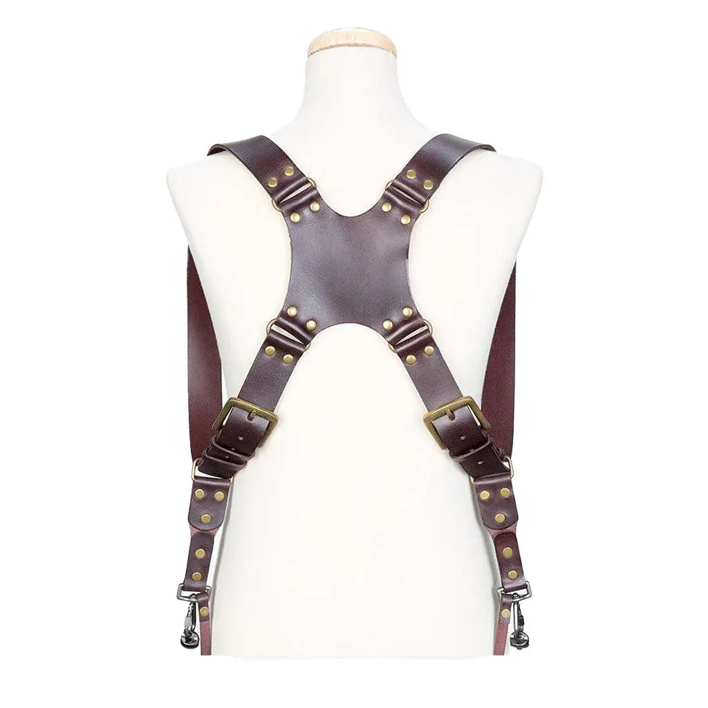Brown leather suspenders with brass hardware on a mannequin against a white background