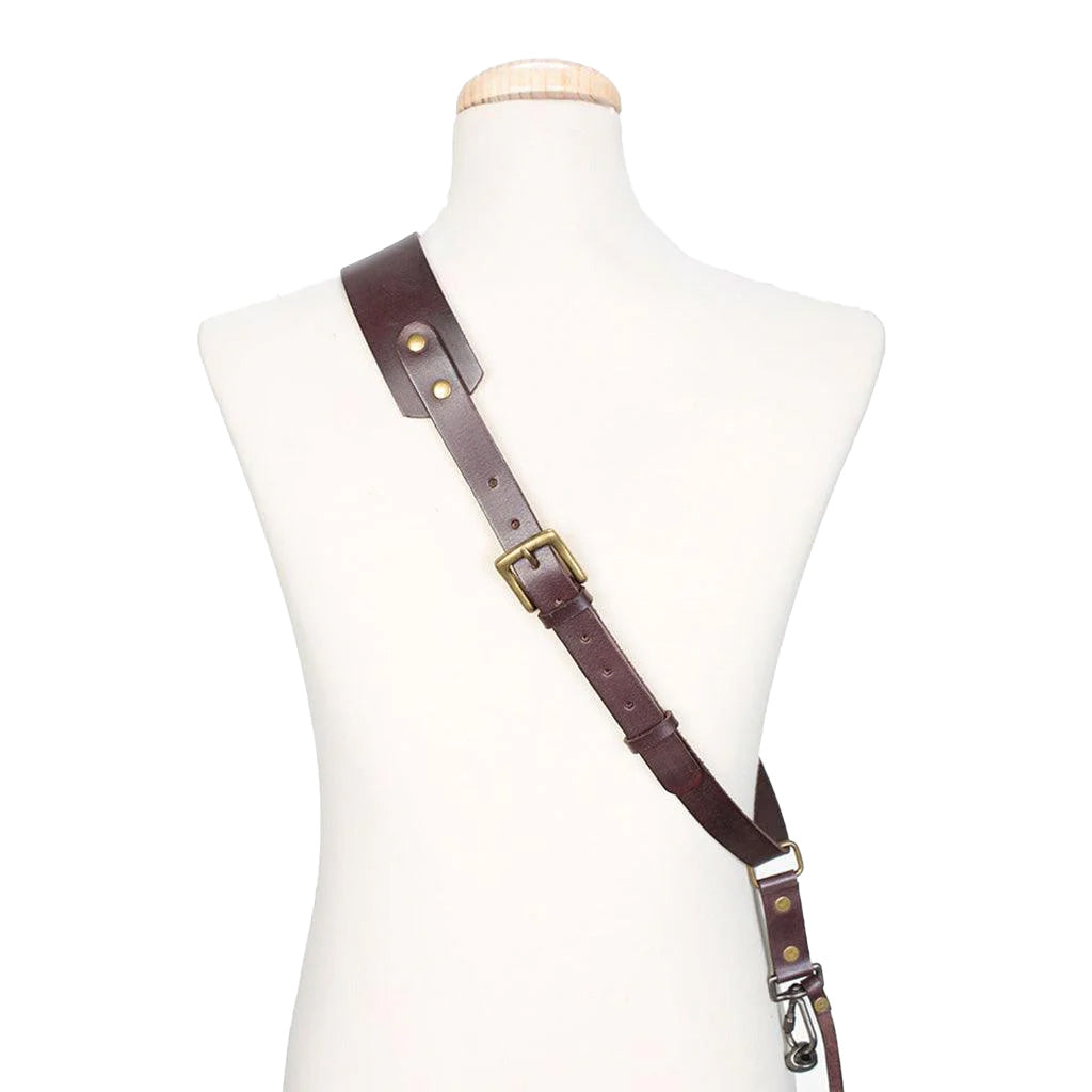 Brown leather strap with brass hardware on a mannequin torso against a white background