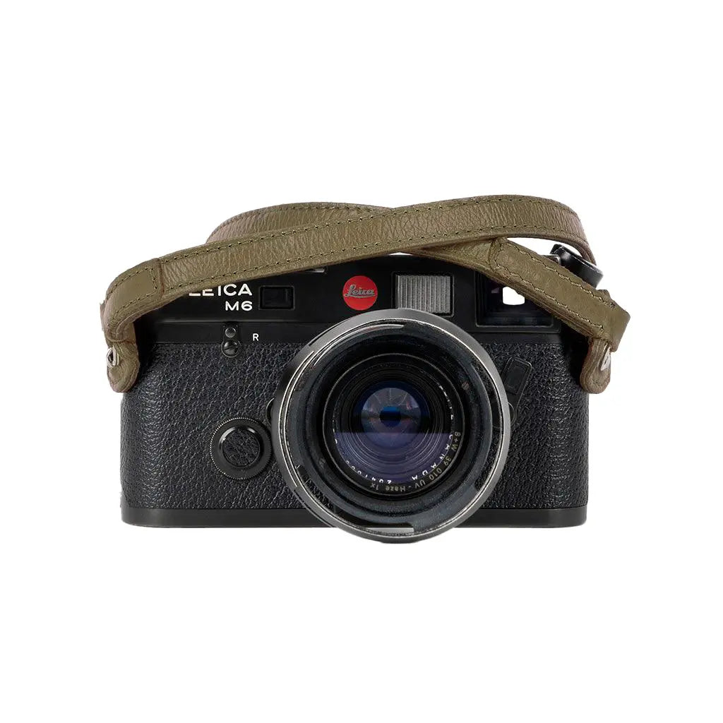 Camera with a leather strap on a white background
