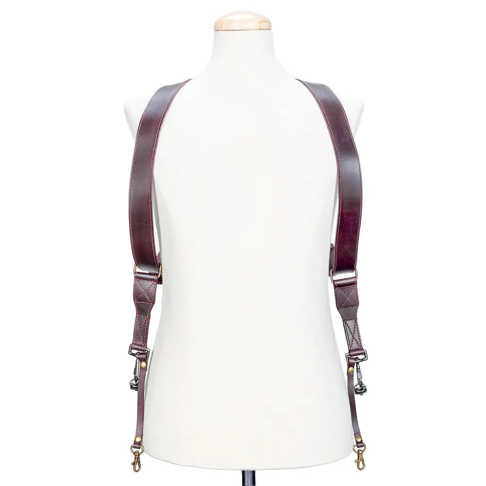 Brown leather suspenders on a mannequin against a white background
