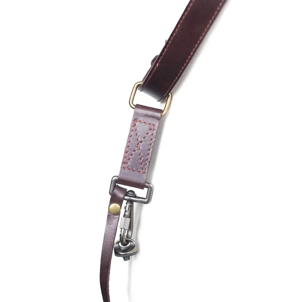 Close-up of a leather strap with metal hardware on a white background