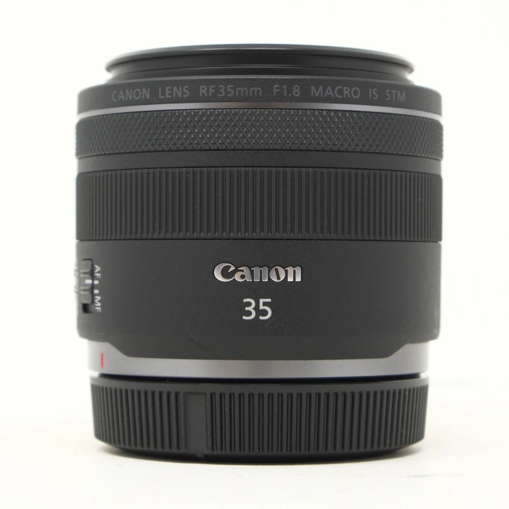 Canon 35mm f/1.8 macro IS STM lens in black with silver text, shown on a white background.
