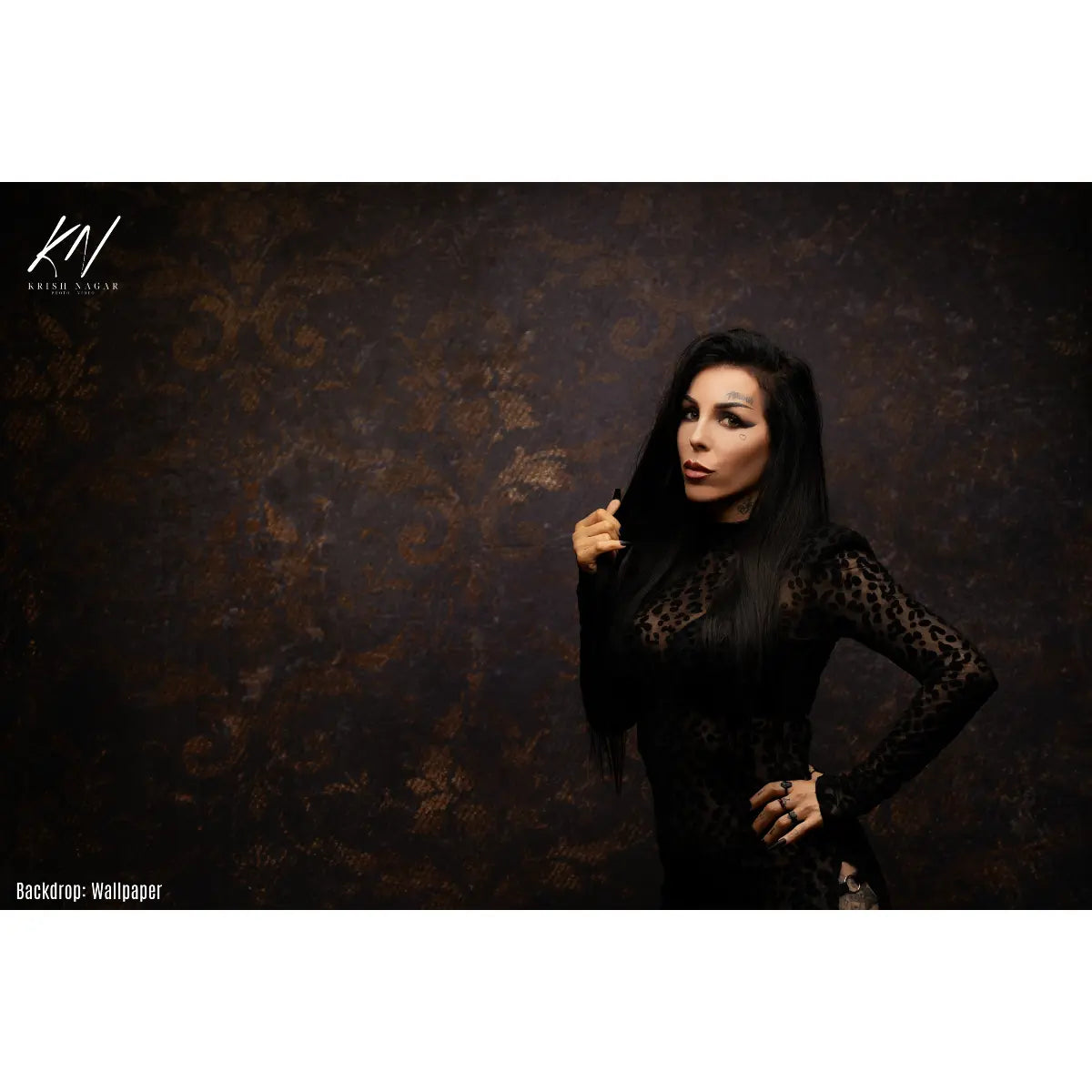 Woman in a black outfit posing against a textured dark background