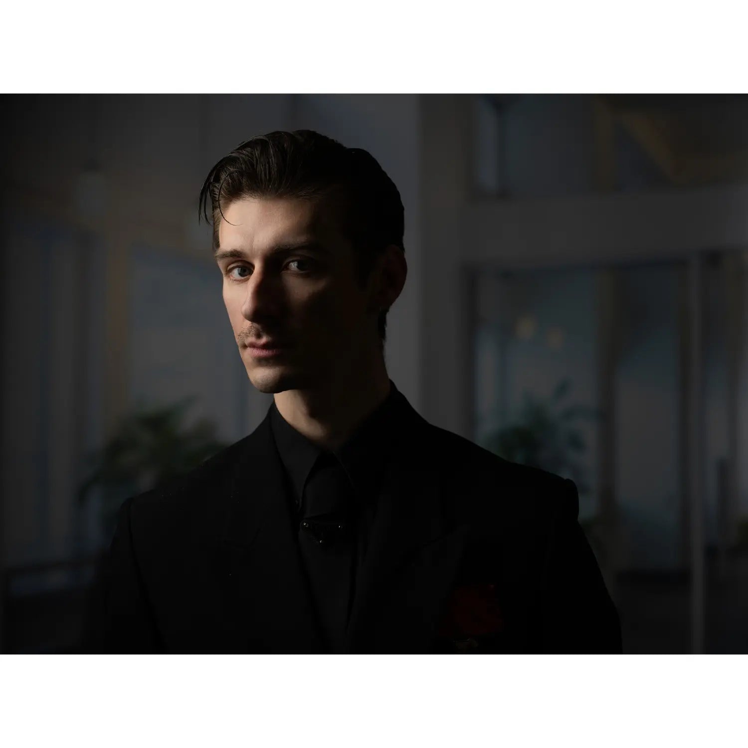 Man wearing a black shirt in a dimly lit room
