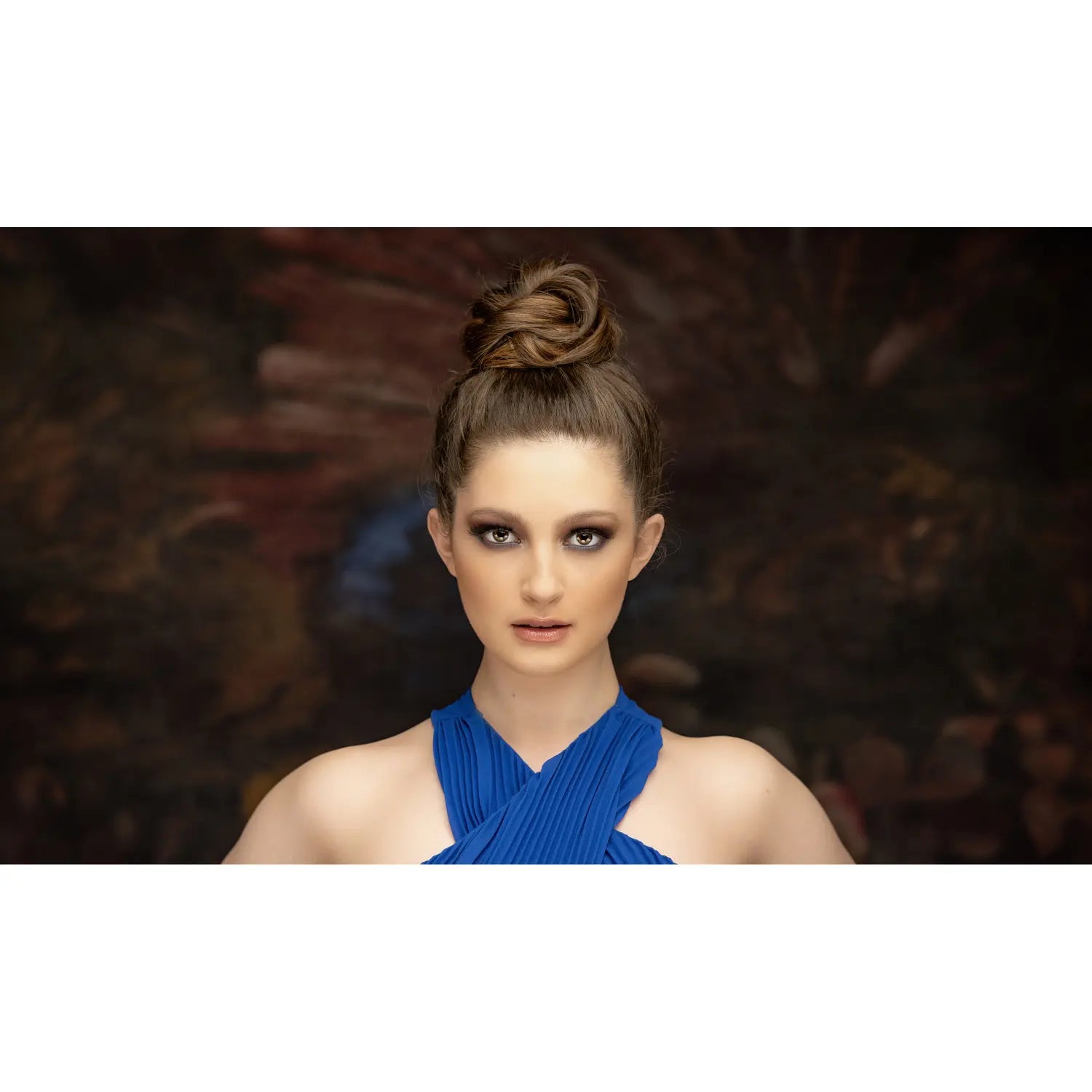 Woman wearing a blue dress with a dark, blurred background