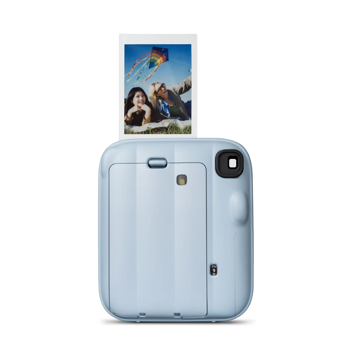 Blue instant camera with a printed photo of a couple and kite on a white background