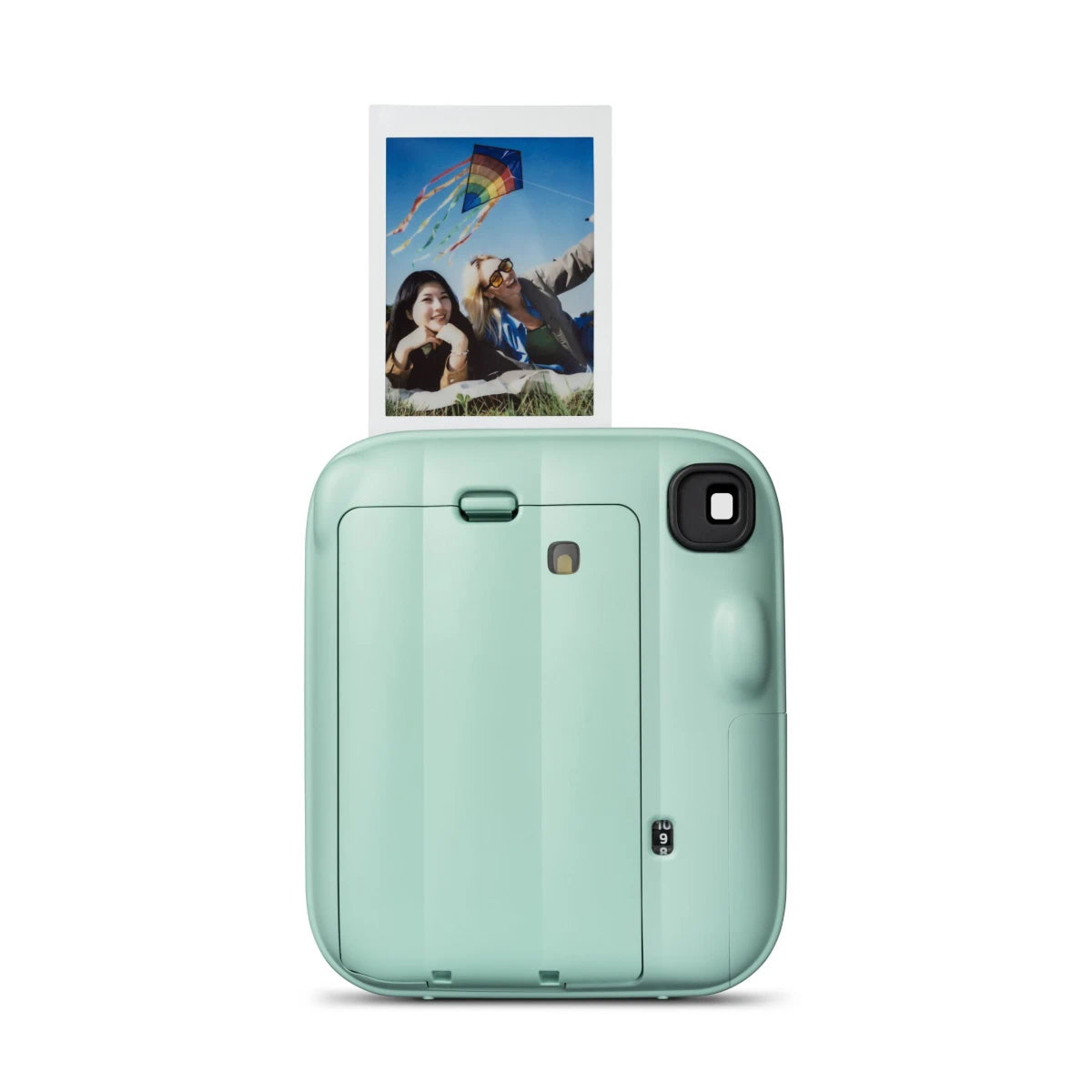 Mint green instant camera with a printed photo of a couple and kite on a white background