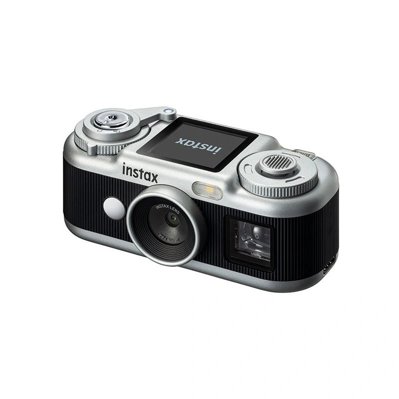 A compact Instax Mini camera in silver and black, shown from a three-quarters angle on a plain white background.