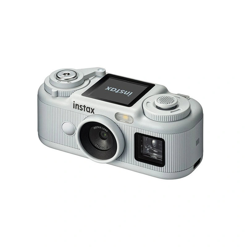 A light silver Instax MiniCam compact camera with a textured grip, shown from a three-quarters angle on a solid white background.