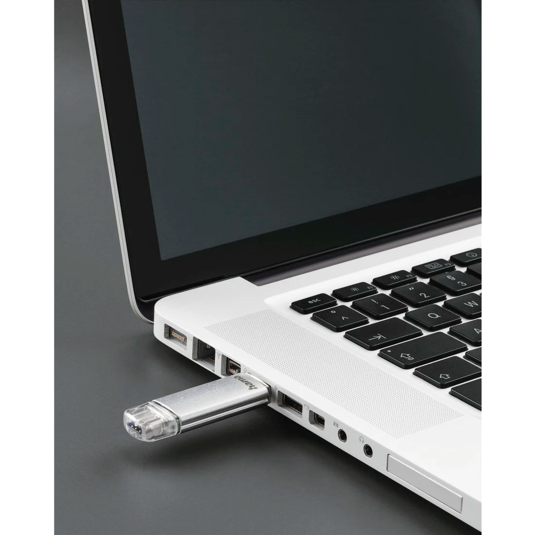 USB flash drive inserted into a laptop on a gray background