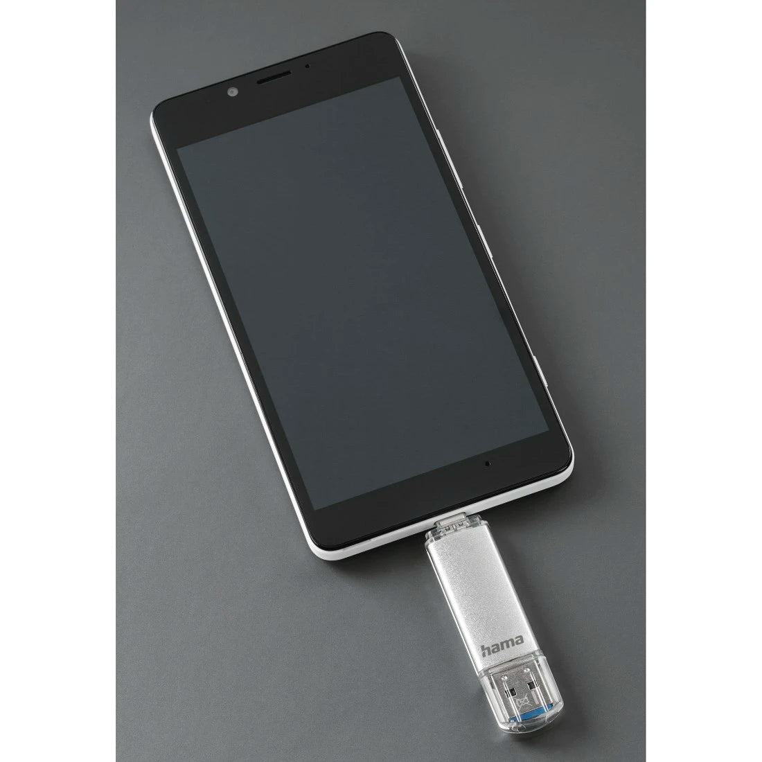 Smartphone with a USB flash drive attached on a gray background