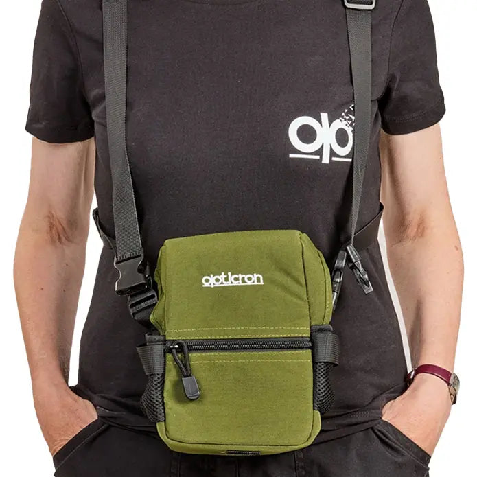 Person wearing a black t-shirt with a logo and a green backpack with 'qotocron' branding.