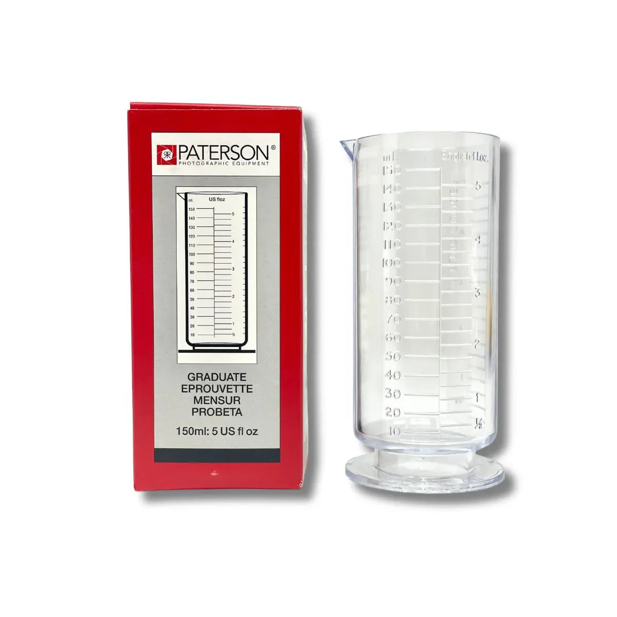 Clear measuring beaker with Paterson branding next to its packaging on a white background