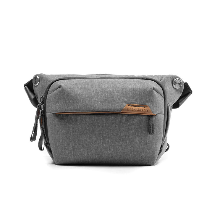 Gray sling bag with a brand logo on a white background