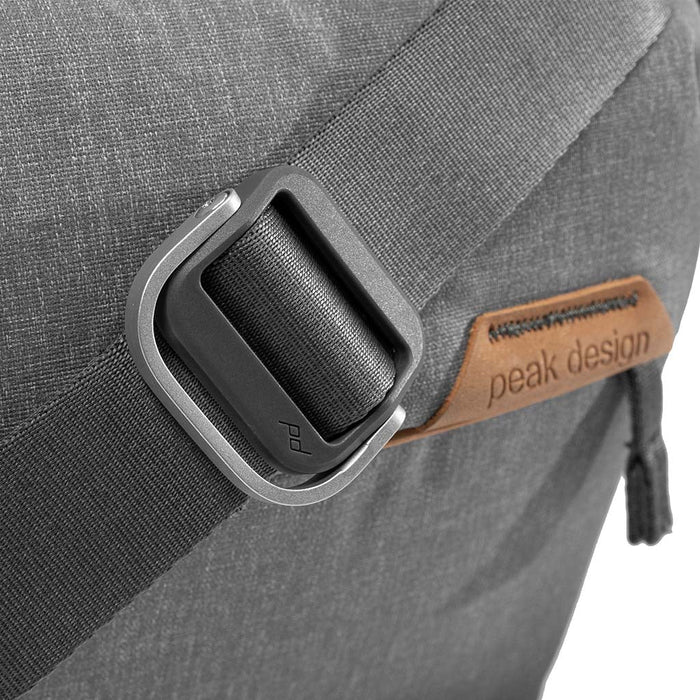 Gray backpack with a visible Peak Design logo on a strap buckle.