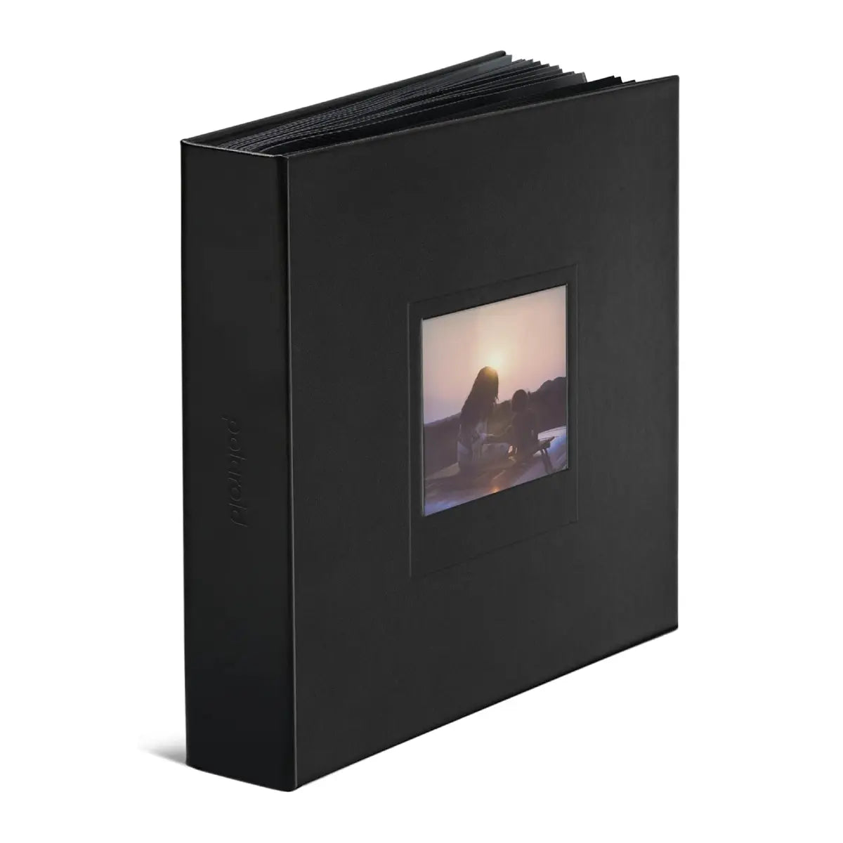 Black photo album with a window displaying a sunset scene on a white background