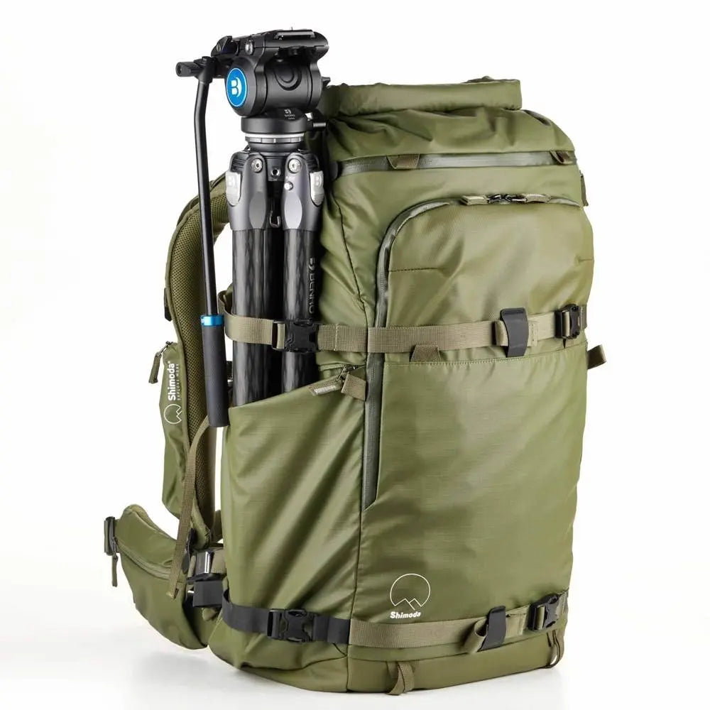 Green backpack with a camera tripod attached on a white background
