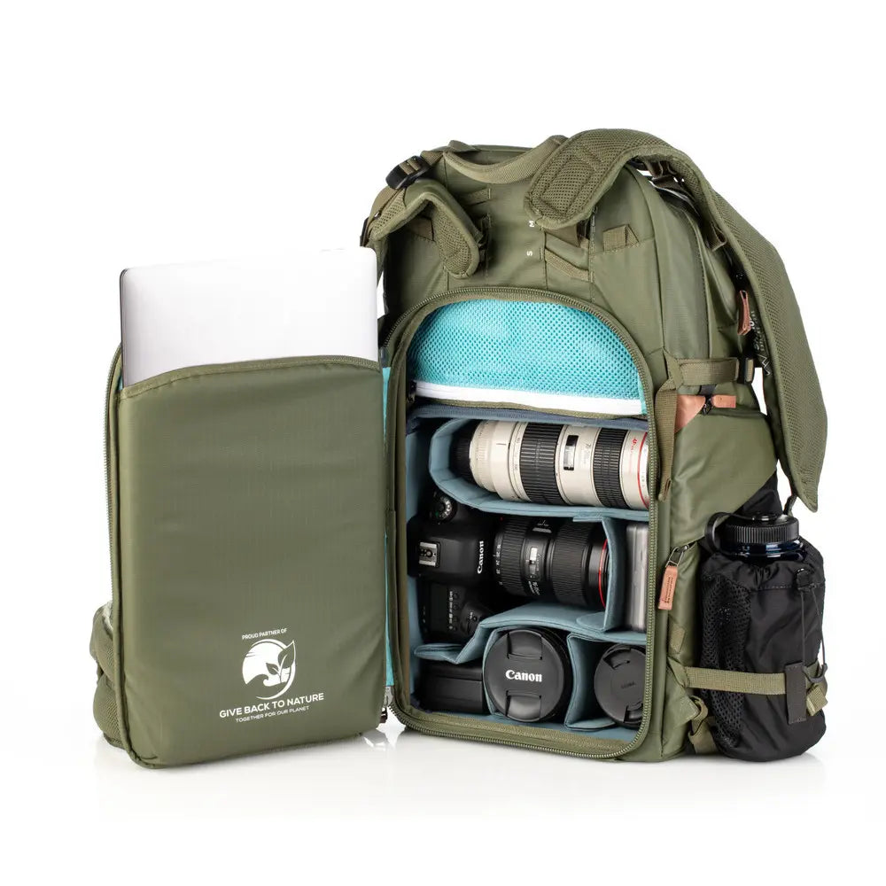 Green backpack with camera equipment and laptop on a white background