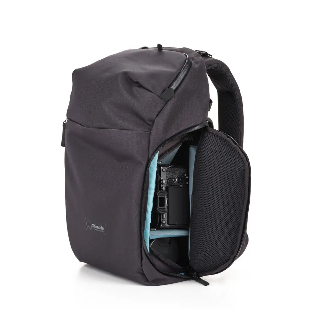 Black backpack with a camera inside on a white background