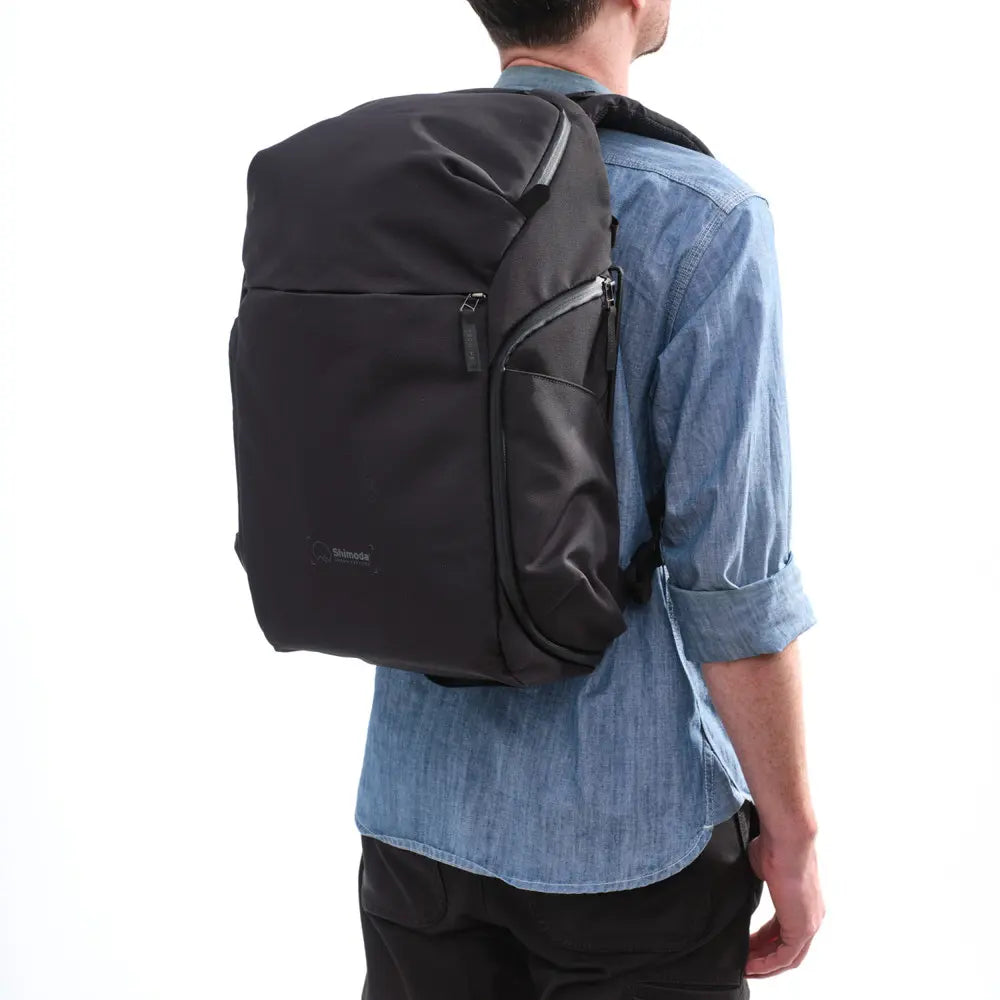 Person wearing a black backpack on a white background