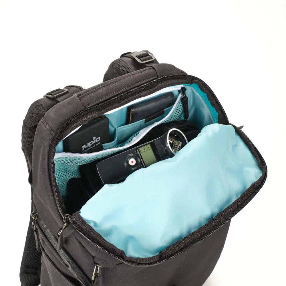 Black backpack with turquoise interior showing a digital camera and other items.