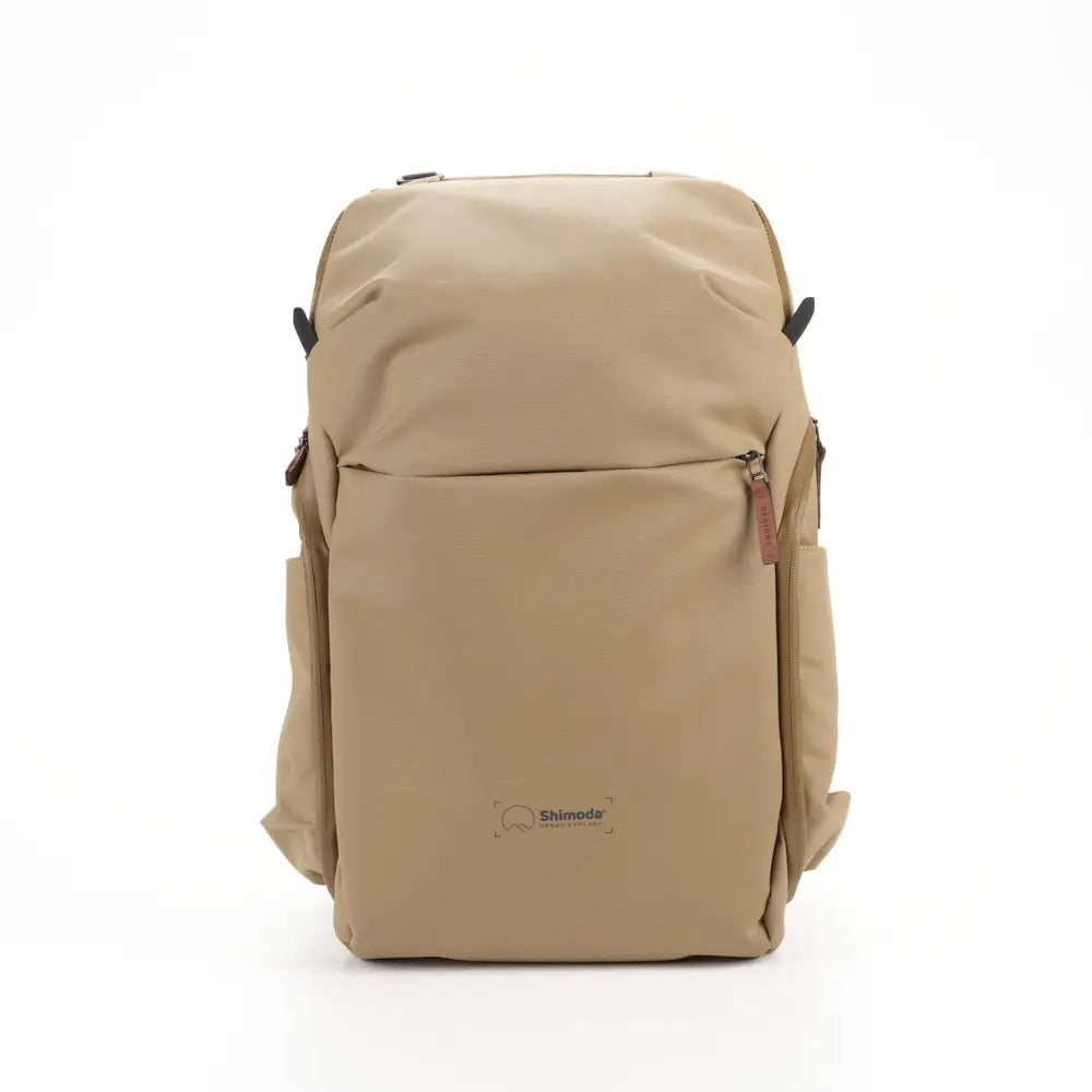 Beige backpack with a visible brand logo on a white background