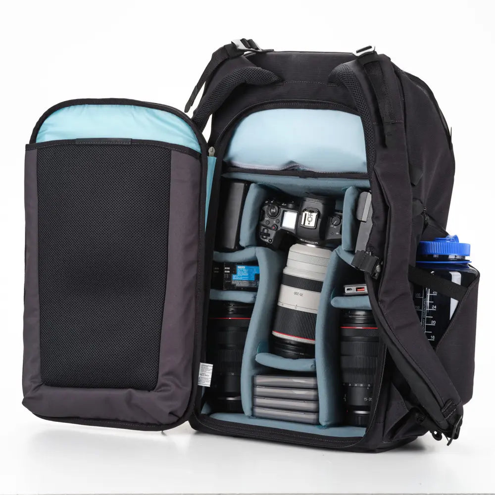 Camera backpack with compartments filled with camera equipment on a white background