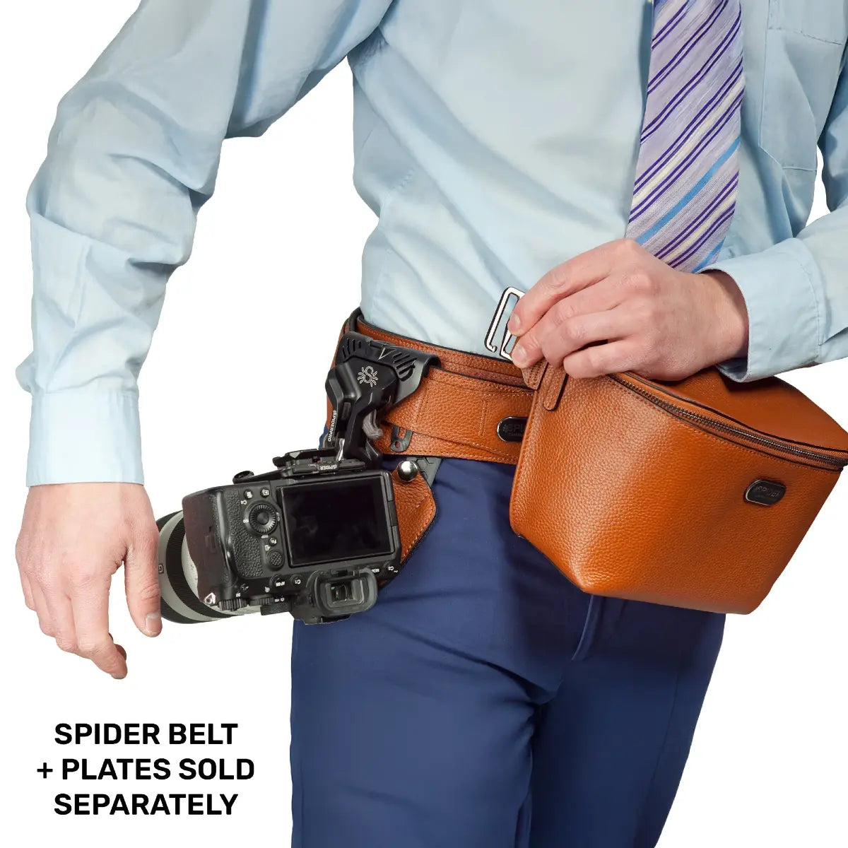 Person wearing a camera belt with a camera attached, holding an orange bag.