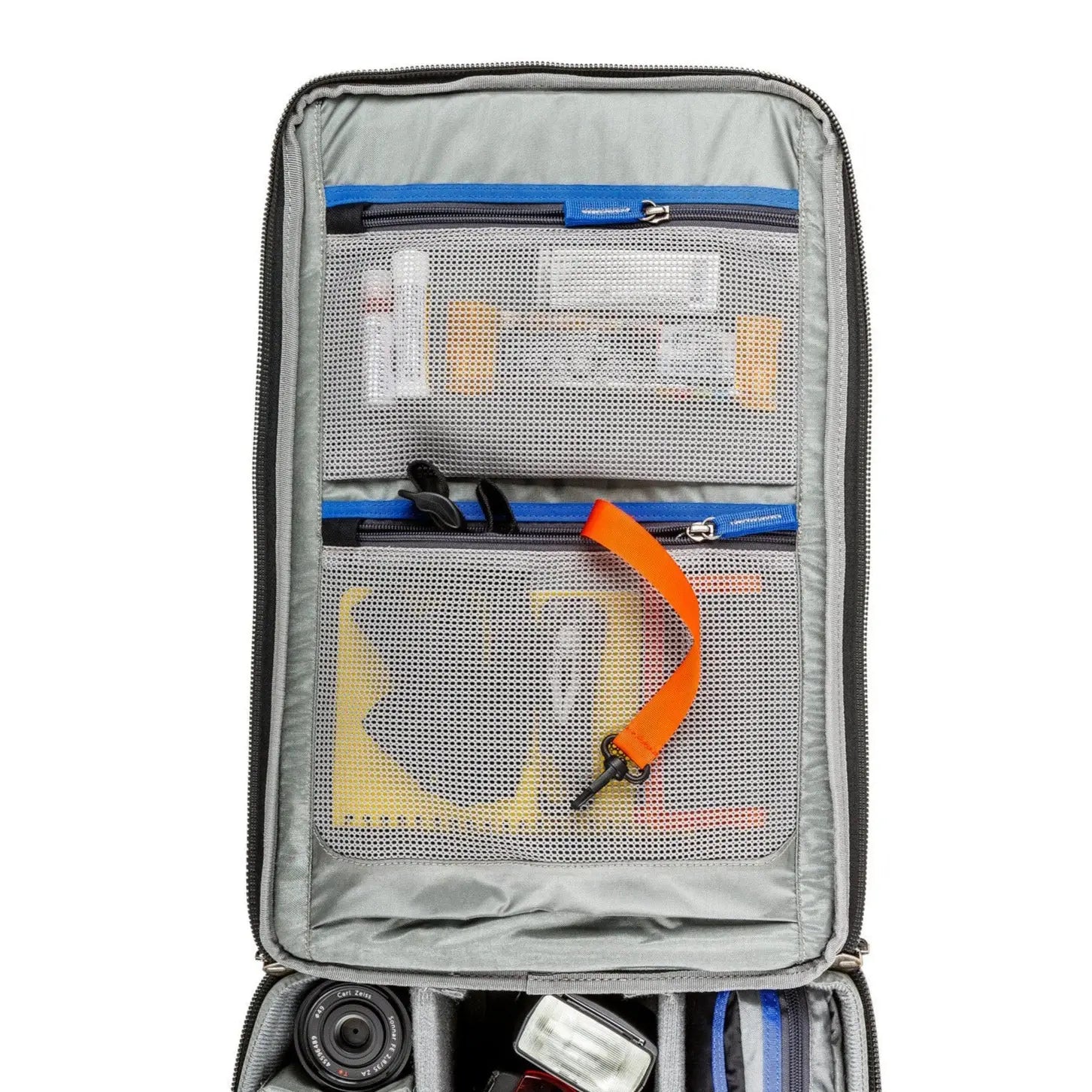 Gray travel organizer with various compartments and items on a white background