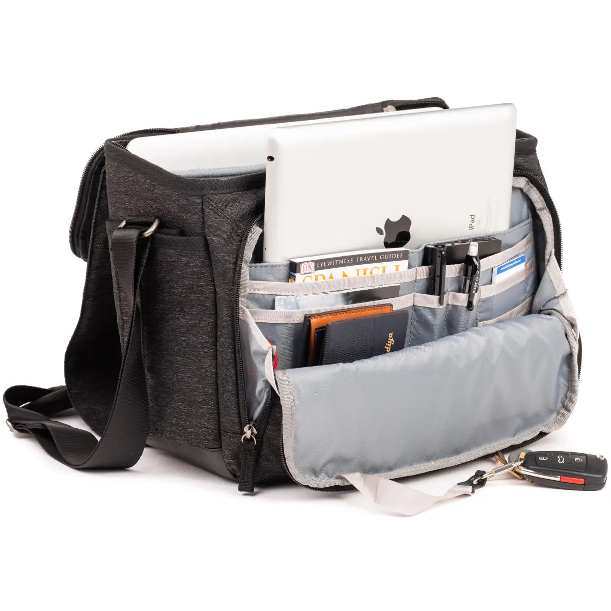 Black and gray bag with compartments containing a laptop, books, and a phone on a white background