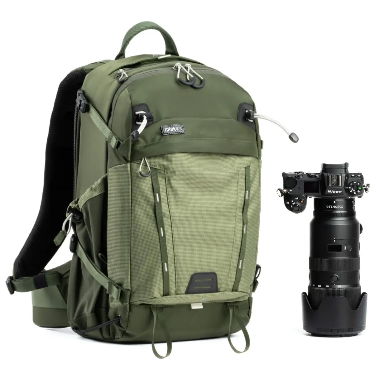 Green backpack with a Nikon camera on a white background
