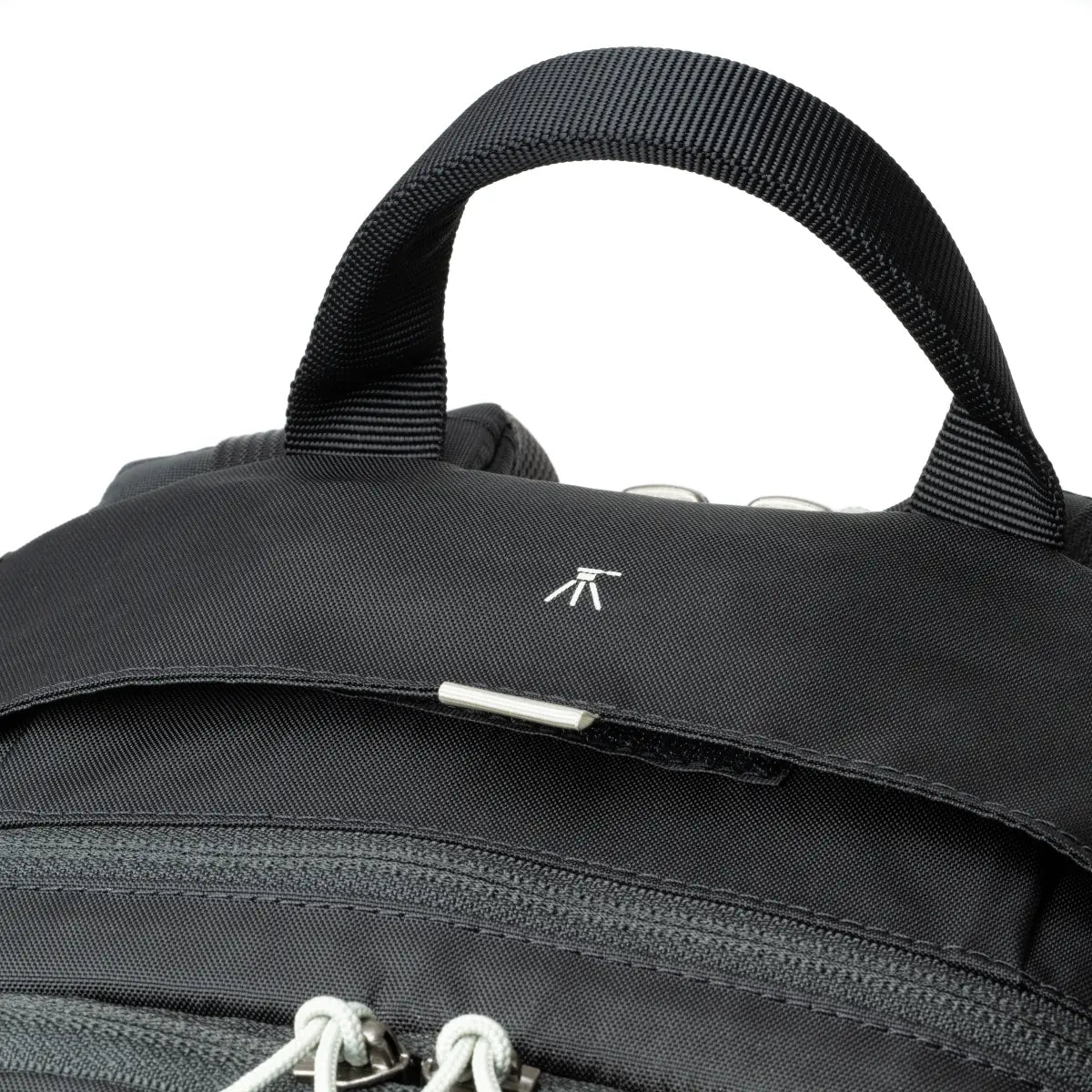 Close-up of a black backpack with a visible brand logo on a white background