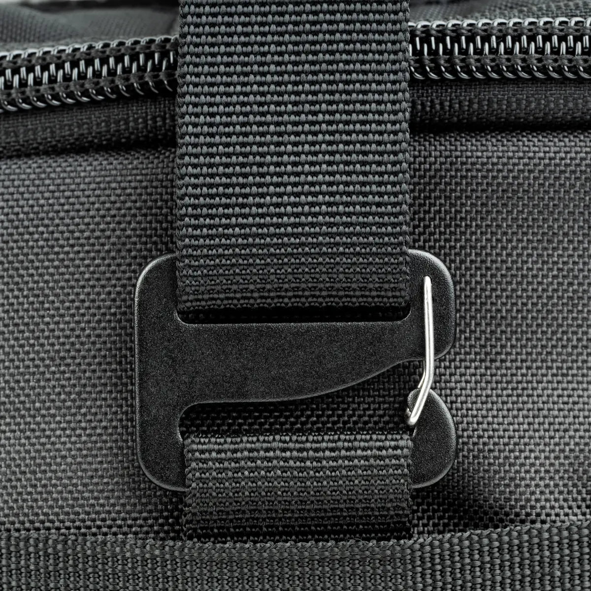 Close-up of a black strap with buckle on a gray textured surface