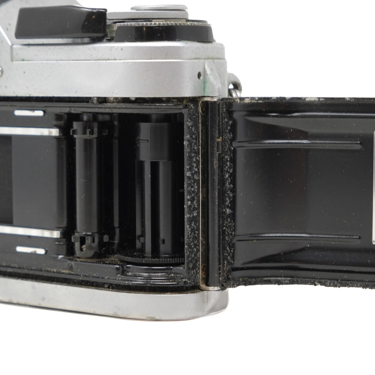 Close-up of a vintage camera with open film back on a white background