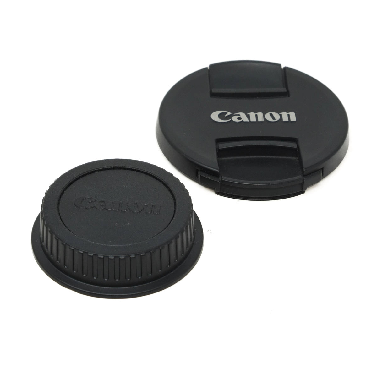 Two black Canon lens caps on a white background