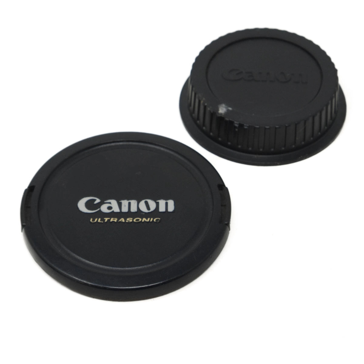 Two Canon lens caps on a white background