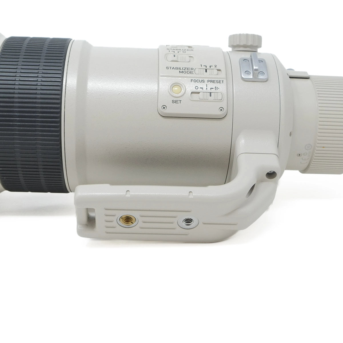 Close-up of a camera lens with control buttons on a white background