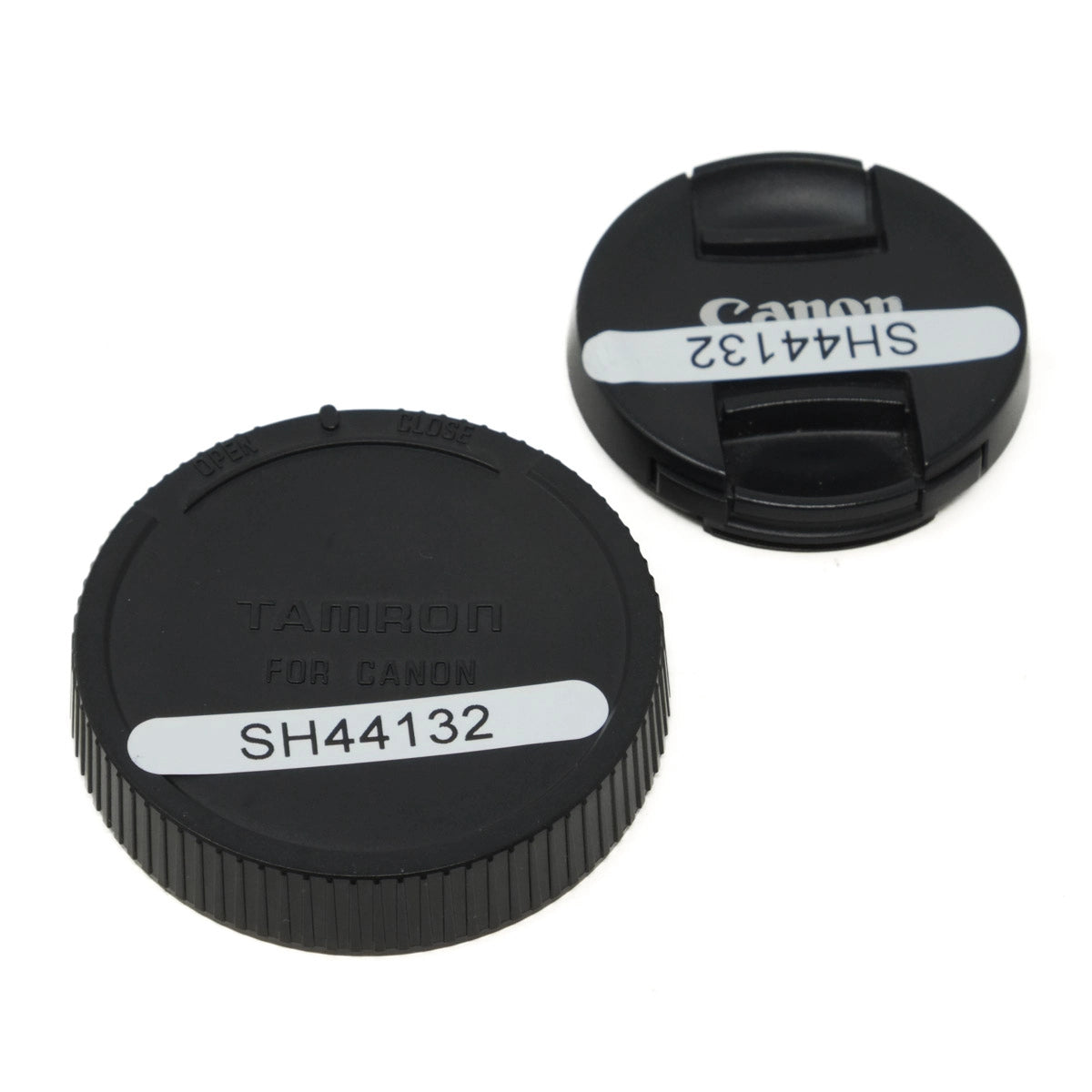 Two black camera lens caps with Tamron and Canon branding on a white background