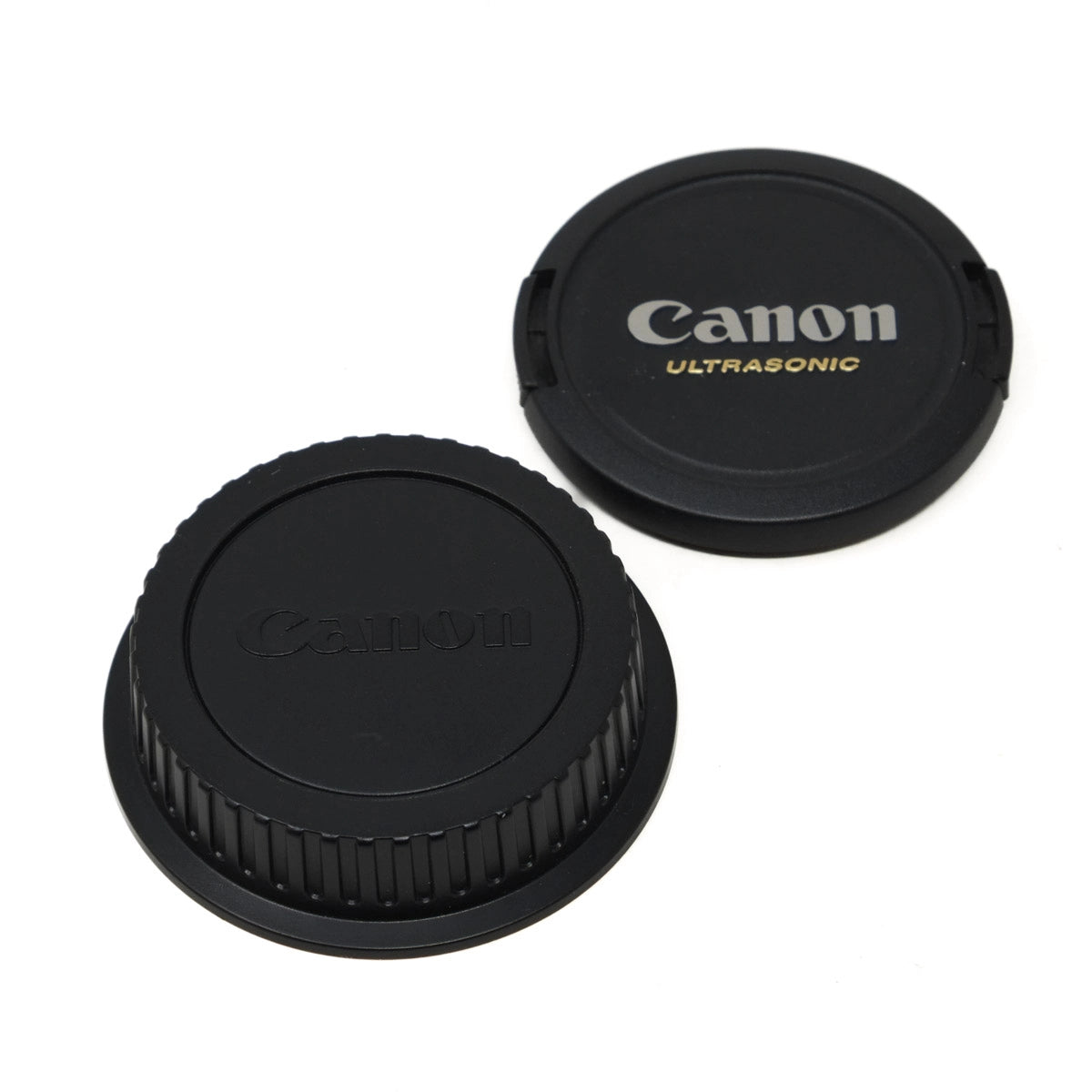 Two Canon lens caps on a white background