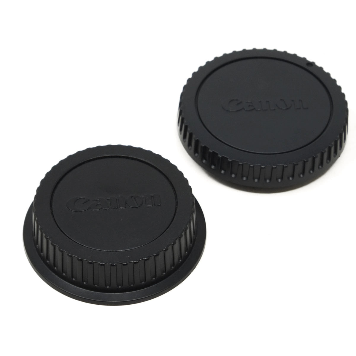 Two black Canon lens caps on a white background